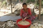 Preparing corn in the shade of the kitchen